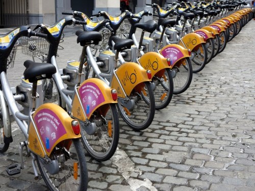Peddling Bicycles — Use of color amidst a mostly monochromatic background; Whimsy; aligning perspective from foreground corner to opposing background corner to draw your eye into the photograph