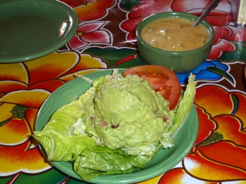 Guacamole in the foreground; Chili con Queso with green chili strips behind